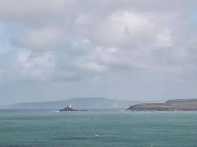 a lighthouse on an island in the middle of the ocean at The Coach House in Hayle