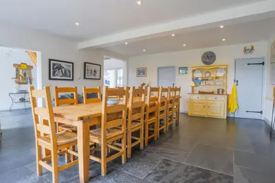 a dining room with a wooden table and chairs at Trewidden in Polzeath