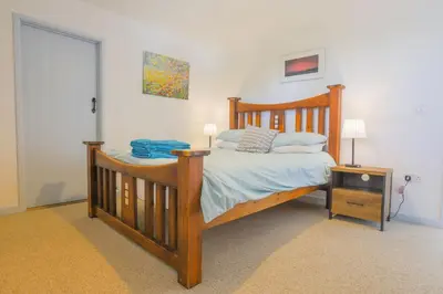 a bedroom with a wooden bed with a wooden frame at Trewidden in Polzeath