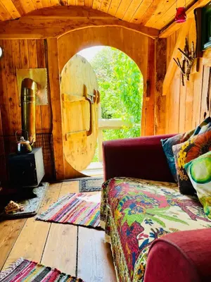 a living room with a couch and a stove at Wrens Nest in Saint Mabyn