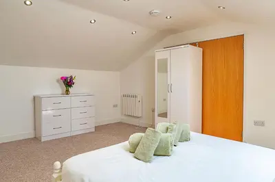 a bedroom with a white bed and a dresser at Finest Retreats - Stable Barn Apartment at Bodmin Moor in Saint Breward