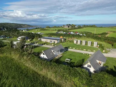 an aerial view of a house on a hill at Celtic Longhouse Tent at Coverack Camping in Coverack