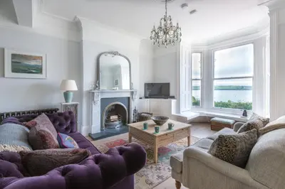 a living room with purple furniture and a fireplace at 5 The Terrace in Padstow