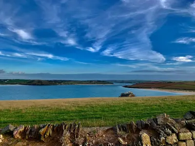 a large body of water with a stone wall at Family-Friendly 3-Bed Caravan Recently Renovated on Seven Bays Holiday Park, Padstow in St Merryn