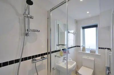 a bathroom with a shower and a toilet and a sink at Foxwood in Kenwyn