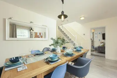 a dining room with a wooden table and chairs at Puffin Way in Hayle