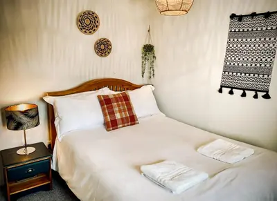 a bed with white sheets and pillows in a bedroom at Hawthorn in Bude