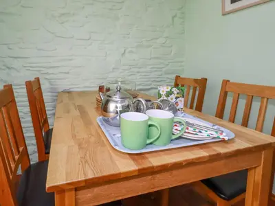 a wooden table with two green coffee mugs on it at The Old Piggery in Truro