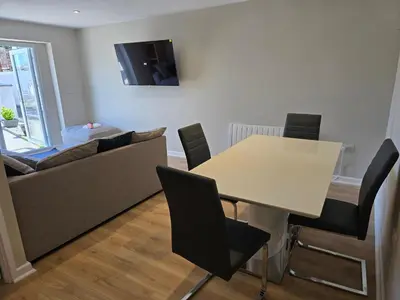 a living room with a table and a couch at Acklington 2 bedroom property in Menheniot