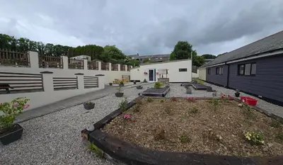 a courtyard with a garden with flowers in it at Acklington 2 bedroom property in Menheniot