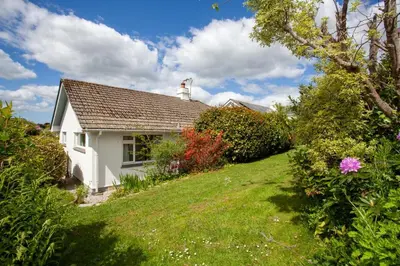 a white house on a hill with a garden at Creek View in Feock