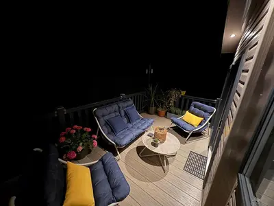 a balcony with two blue chairs and a table at Serenity in Saint Erth