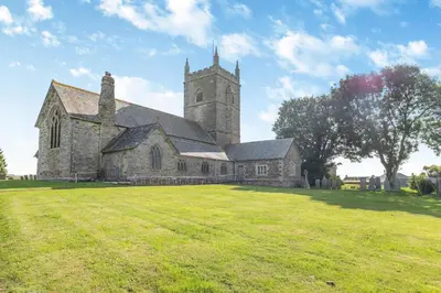an old church with a grass field in front of it at 2 Bed in St. Issey oc-o27778 in Saint Issey