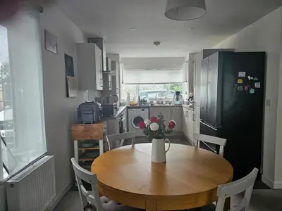 a kitchen with a wooden table with a vase of flowers on it at House in Cornwall in Redruth