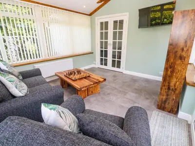 a living room with two couches and a table at Little Acorns in Helston
