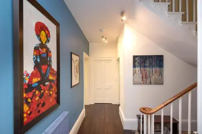 a hallway with a painting on the wall at The Vicarage - Grand Country House, Walking Distance to Padstow and with Pub Across the Road in Wadebridge