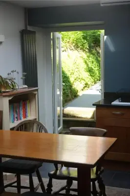 a dining room with a table and chairs and a door at Dunlin Cottage in Penryn