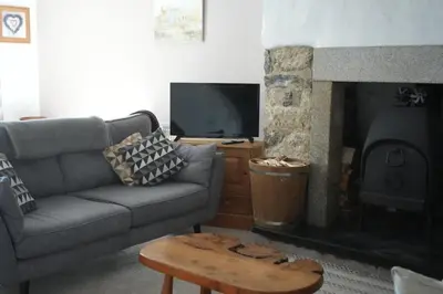 a living room with a couch and a fireplace at Dunlin Cottage in Penryn