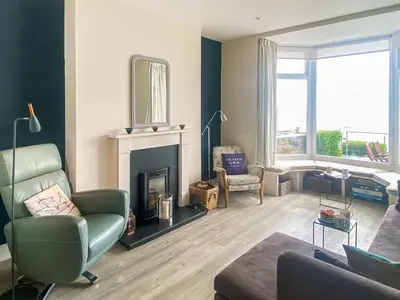 a living room with a couch and a fireplace at Coastguards in Porthscatho