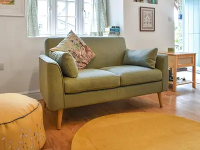 a green couch in a living room with a table at Roseland Retreat - Uk49838 in Truro