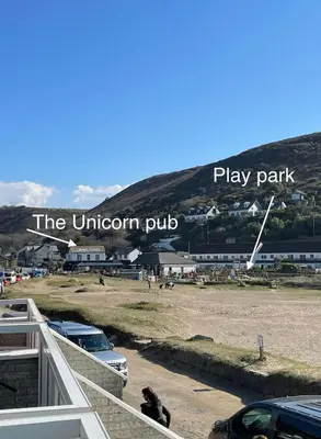 a dog sitting on the balcony of a play park at Surf 'n' Sands in Porthtowan Beachfront Apartment in Porthtowan