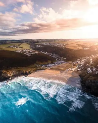 an aerial view of a beach and the ocean at Surf 'n' Sands in Porthtowan Beachfront Apartment in Porthtowan