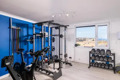 a gym with cardio equipment and a window at Blue Mist Apartment in St Ives