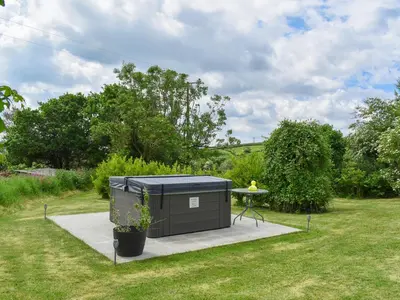 a black container with a table in a yard at The Old Workshop - Uk49871 in Lanivet