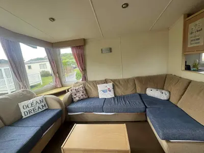 a living room with a sectional couch and windows at Pet Friendly Static in Carnbrea Station
