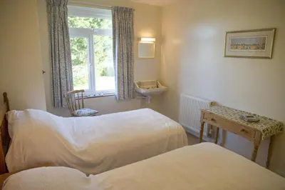 a room with two beds and a sink and a window at Wesdale Holiday Home in Polzeath