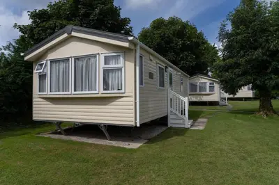a large white caravan parked in a yard at Trevarth Holiday Park in Chacewater