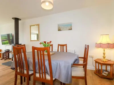 a dining room with a table and chairs and a fireplace at Folly View in Redruth
