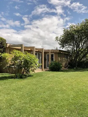 a house with a grass yard in front of it at SeaNest, Aggie Home by the sea in St. Agnes