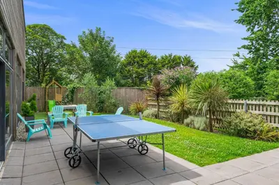 a ping pong table and chairs on a patio at House 18 in Looe
