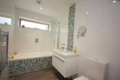 a bathroom with a tub and a sink and a toilet at House 18 in Looe
