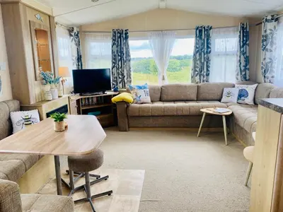 a living room with a couch and a table at Calm View in St Austell