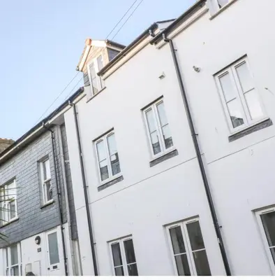 a white building with windows on a street at Falmouth Retreat - Family stays in Falmouth