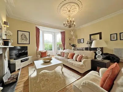 a living room with a couch and a chandelier at Trenare in Truro