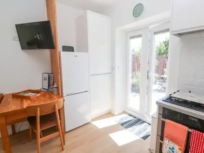 a kitchen with a table and a white refrigerator at Carn Brea in Redruth