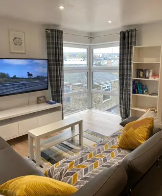 a living room with a couch and a flat screen tv at Lovely 1 bedroom flat in the heart of Newquay in Newquay