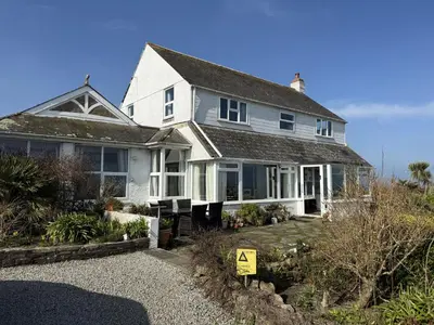 a white house with a sign in front of it at 1 The Links in St Ives