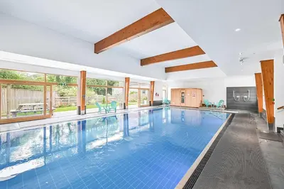 an indoor swimming pool with blue tiles in a house at House 3 in Looe