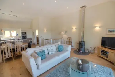 a living room with a white couch and a television at House 23 in Looe