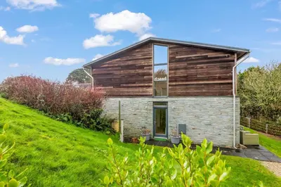 a house on a hill with a green yard at House 36 in Looe