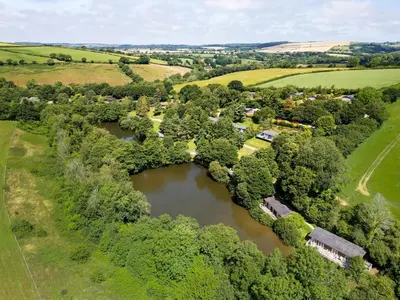 an aerial view of a village with a river at 2 Tree Tops in Looe