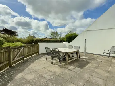 a patio with a table and chairs on a patio at Chough at Highcliffe in Polzeath