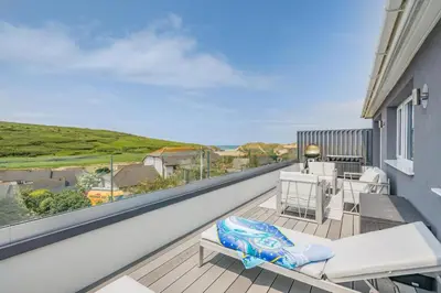 a balcony with white furniture and a view of the ocean at 2 Bed in Newquay oc-b32399 in Holywell Bay