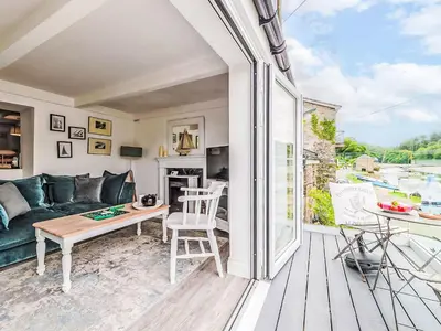 a living room with a couch and a table at Holiday Home Riverside Cottage by Interhome in Lerryn