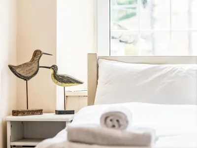 a bedroom with a bed with a bird statue on a table at Holiday Home Tregony House by Interhome in Mevagissey