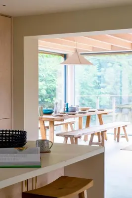 a kitchen with wooden tables and a large window at The Architects Treehouse in Mount Hawke